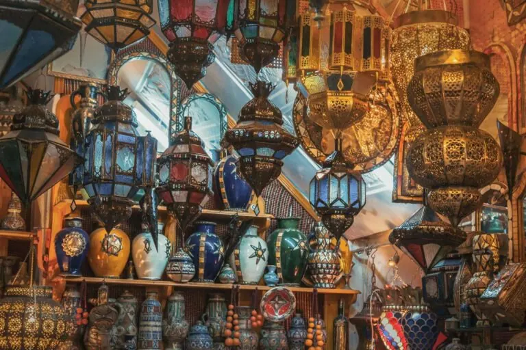 A display of ornate lanterns and colorful ceramic vases arranged on shelves in a market stall.